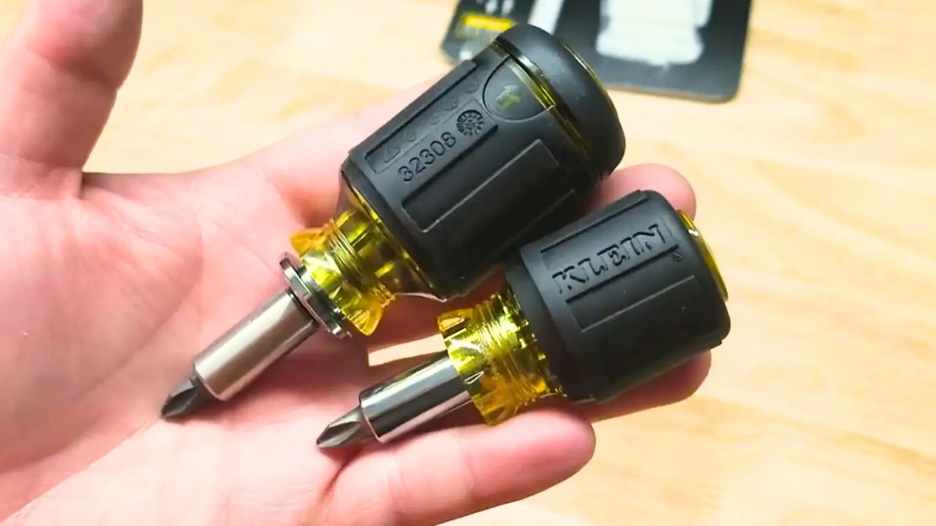 The Klein 32561 7-in-1 ratcheting stubby screwdriver lying on a wooden workbench, reviewed by Smart AI Gears
