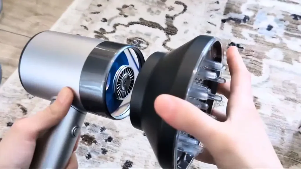 A person easily connecting the magnetic diffuser attachment to the AirLight Pro hair dryer.