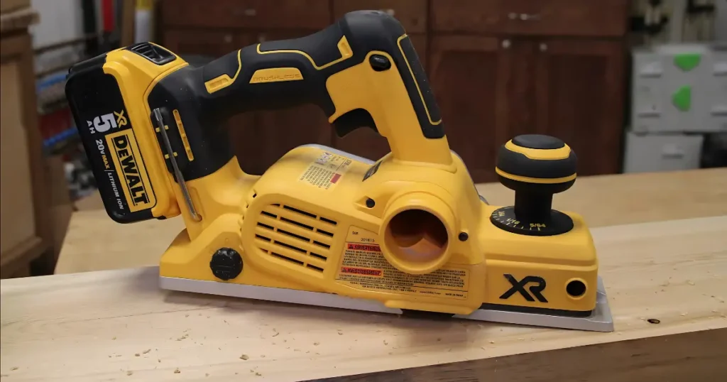 Side profile of the DEWALT 20V MAX Cordless Planer (DCP580B) on a wooden board, showing the depth adjustment knob, dust port, and XR branding.