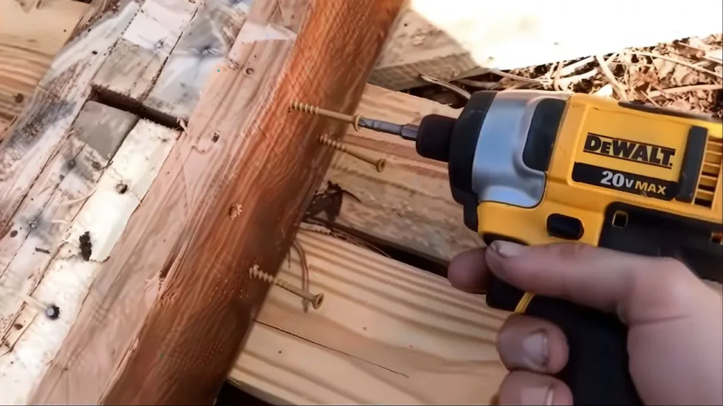 A person using the DEWALT DCF885 impact driver to drive long screws into wood