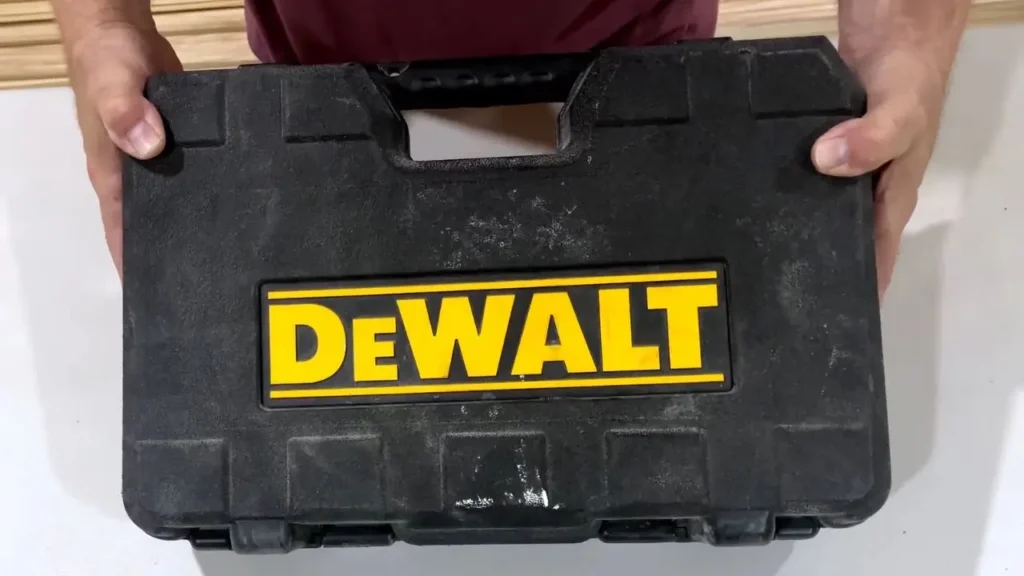 A person holds a closed black DEWALT tool case with a bright yellow DEWALT logo, representing the storage for the DEWALT PEX Expander.