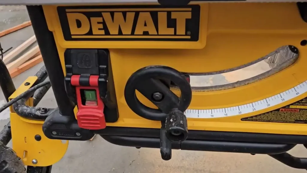 Close-up of the red power switch and black depth adjustment wheel on the DeWalt DWE7491RS table saw