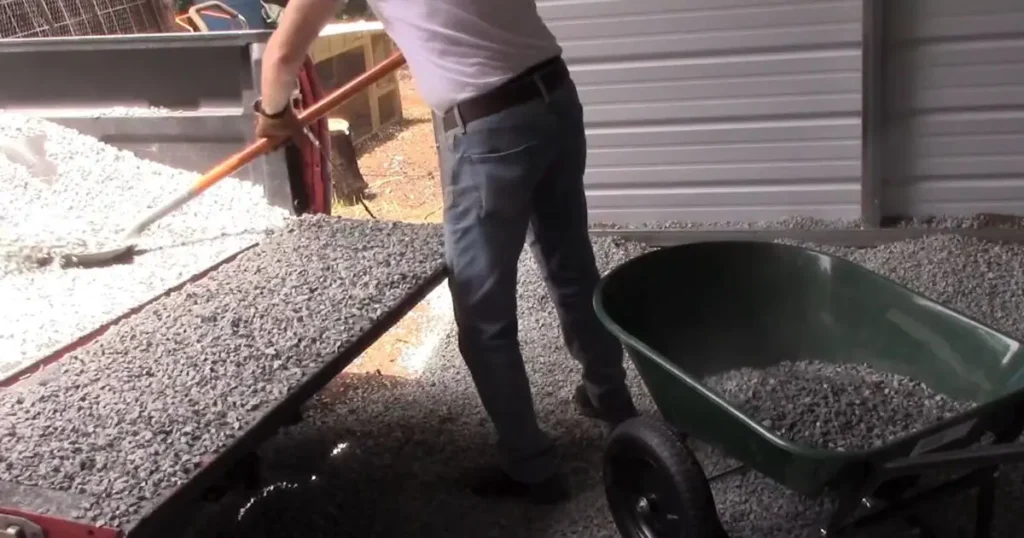 Man using the Dual Wheel Wheelbarrow to move gravel from a pickup truck