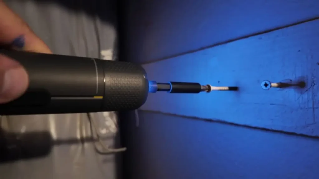 The Fanttik S2 Pro screwdriver putting a screw into a blue wooden board.