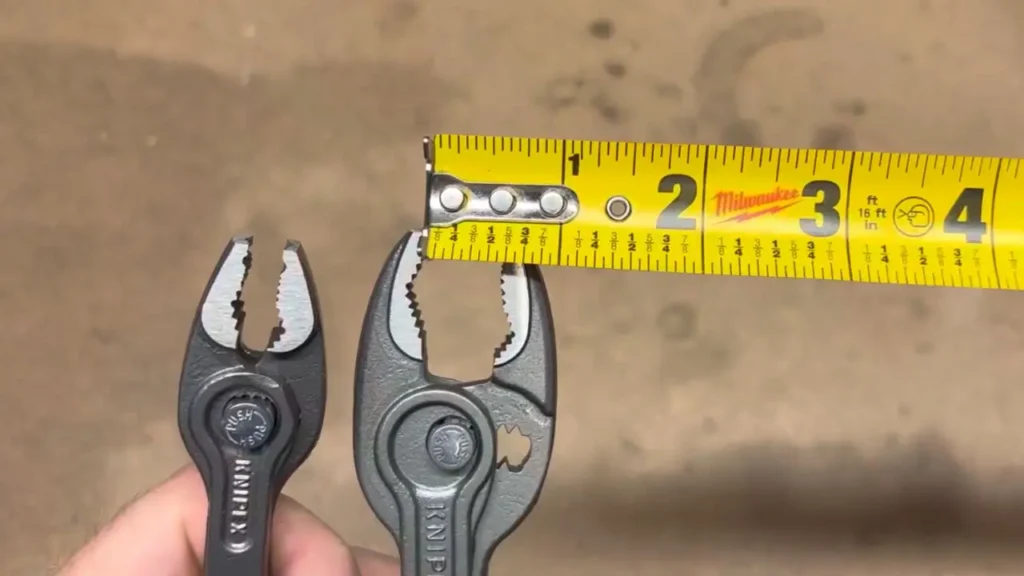 Measuring the jaw opening capacity of the Knipex TwinGrip pliers with a tape measure to confirm its specifications.
