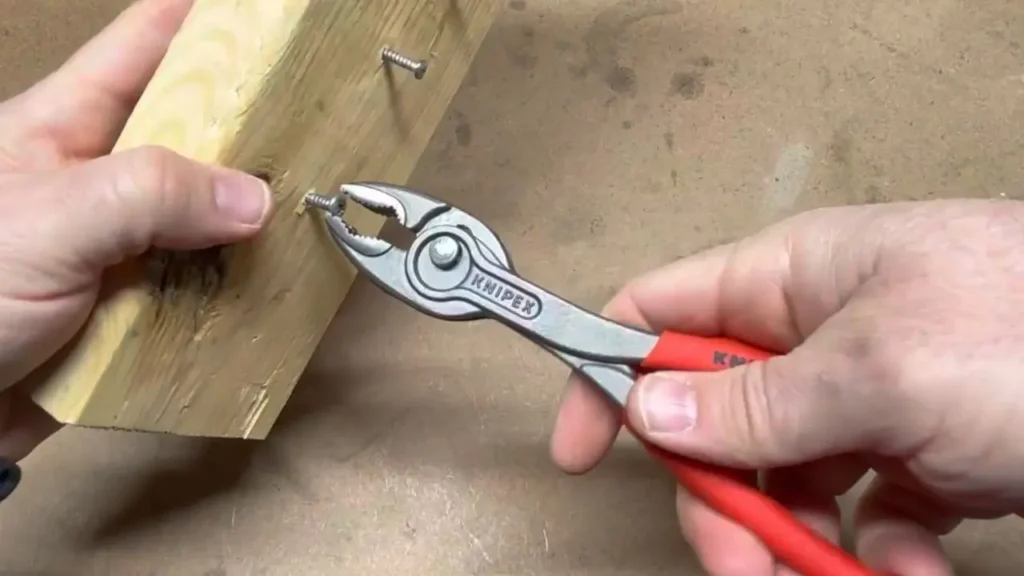 A user demonstrating the Knipex TwinGrip 82 01 200 review by gripping the head of a stripped screw in a piece of wood. Smart AI Gears