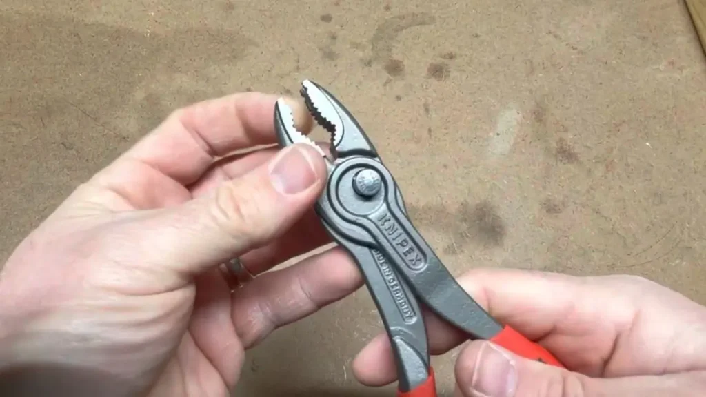 A user demonstrating the easy push-button adjustment mechanism of the Knipex TwinGrip pliers.