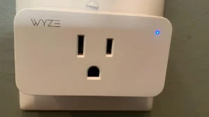 Wyze Plug showing its small size, plugged into a wall outlet. Reviewd at Smart AI Gears