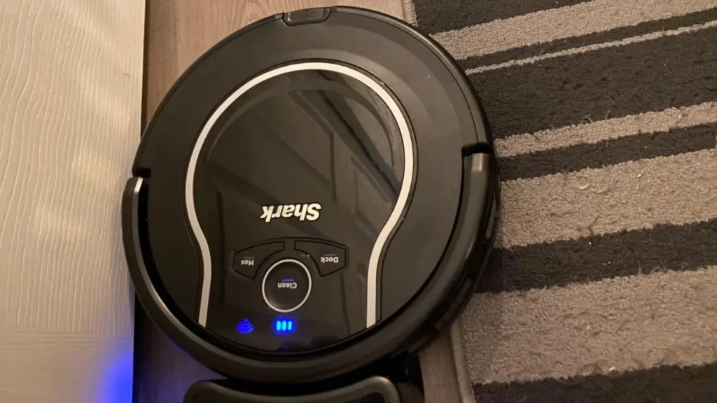 A top view of the Shark ION Robot Vacuum AV751 highlighting its self-cleaning brushroll system.