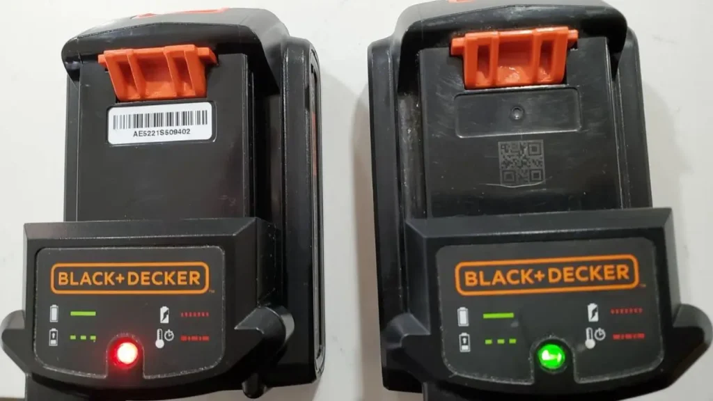 Close-up of Black+Decker 20V MAX batteries on charger, one showing red light.