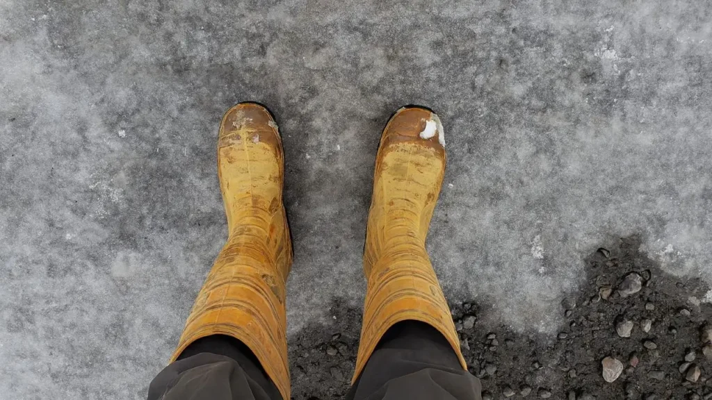 Overhead shot of Cofra Thermic steel toe boots standing on a completely icy surface, highlighting their stability in freezing temperatures.