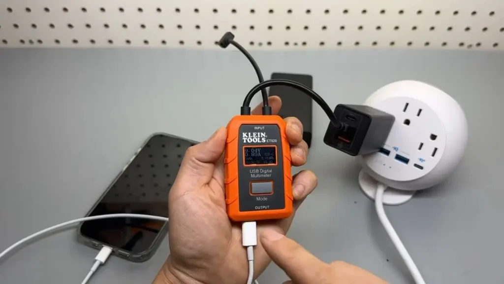 Klein Tools ET920 USB Meter connected to a USB-C charger, showing its use for USB-C compatibility testing in natural light.