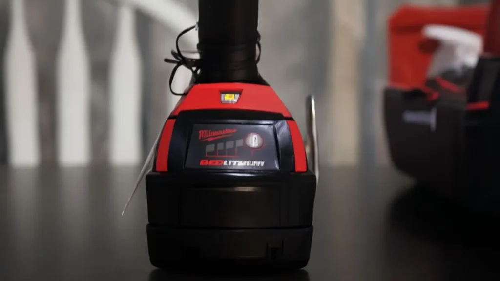 The LED fuel gauge on the M18 REDLITHIUM battery showing the remaining charge level, with the work light on.