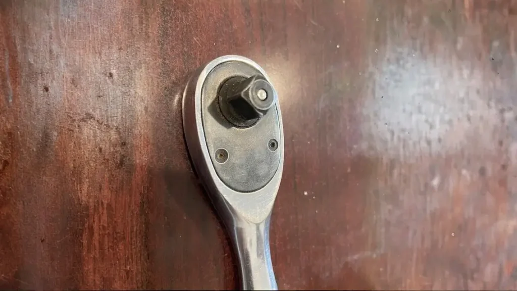 A close-up shot of the pear head ratchet from the DEWALT set, showing the quick-release button and a small 5° arc swing.
