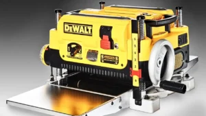 A detailed, high-resolution product shot of the DEWALT DW735X thickness planer with its yellow body and metal base. Reviewed at Smart AI Gears.