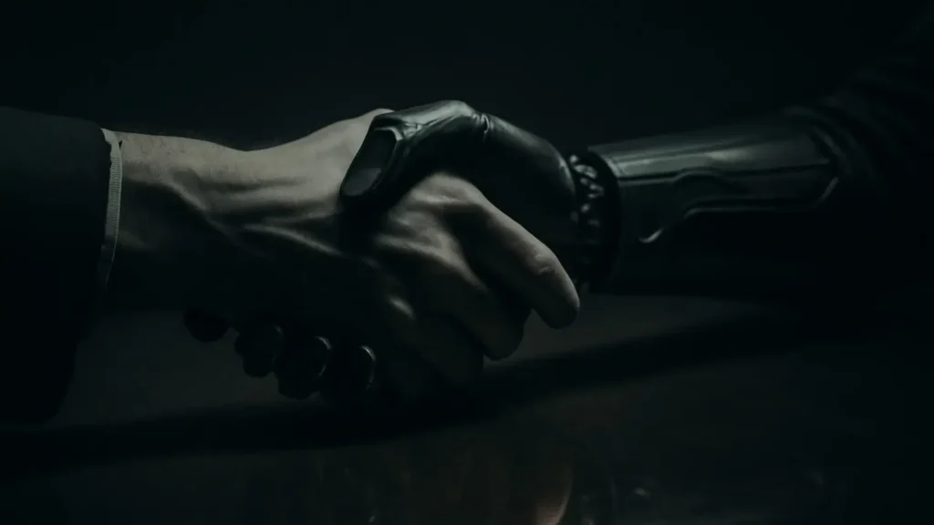A human hand and a robotic hand clasped together. The robotic hand’s reflection looks human, while the human hand’s reflection looks mechanical, illustrating the challenge of the Turing Test and the illusion of consciousness.