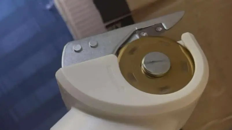 A close-up view of the spinning, titanium-coated blade of the EXPEDMAN scissors.