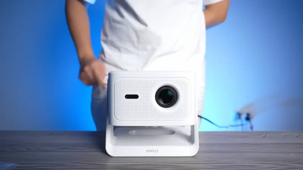 A front-on photo of the VOPLLS M10 projector with its lens and protective covering visible.