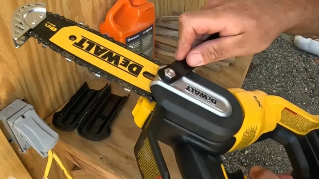 A close-up of a person's hands adjusting the chain on a DEWALT 20V chainsaw.
