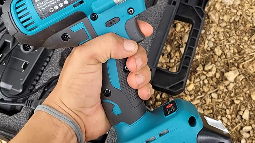 Side by side comparison of the blue SeeSii impact wrench and the teal Makita impact wrench resting on a dirty workbench.