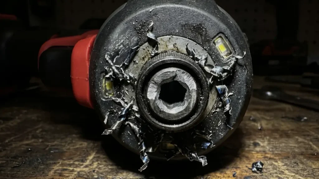A sheared off hex-to-socket steel adapter broken inside a power tool chuck.