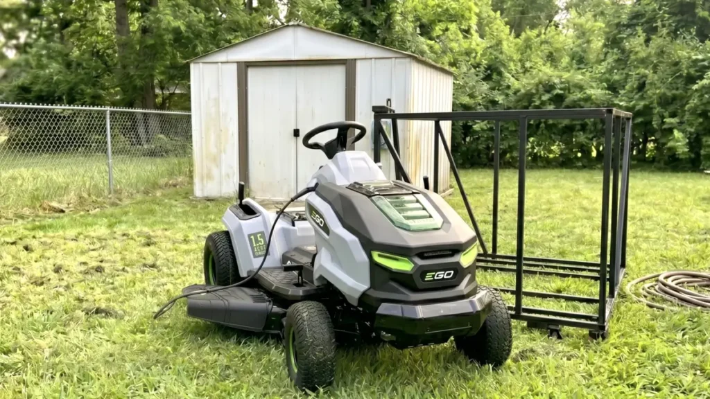 Disassembling the heavy steel shipping crate to unbox the electric lawn tractor in a driveway.