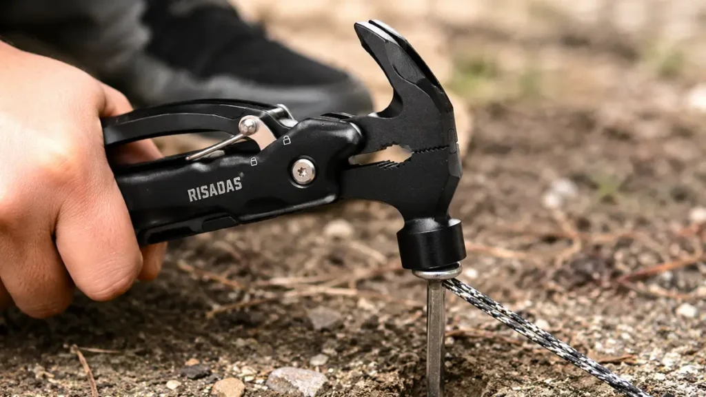 Close-up of Risadas multitool hammer head striking a tent stake.
